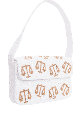 White handbag with gold scales of justice symbols on a white background