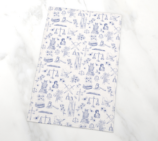 White towel with blue illustrations of scales and other items on a white background