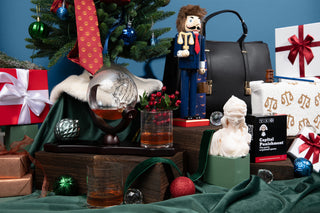 Decorative setup with Christmas tree, gifts, and various items on a table.