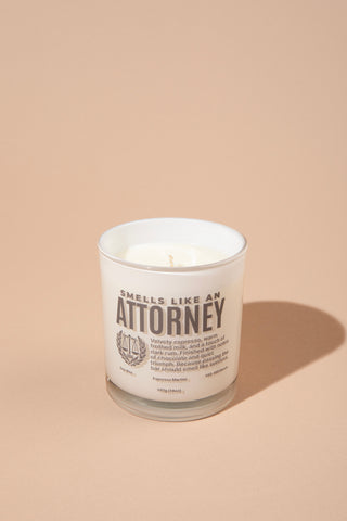 Candle with text 'Smells like an Attorney' on a beige background