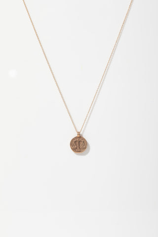 Gold necklace with a pendant on a white background