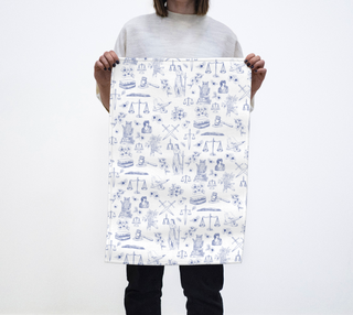Person holding a large white paper with blue illustrations of various objects on a white background
