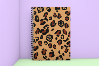 Notebook with leopard print cover on a purple background